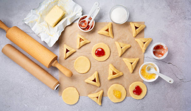 dough, jam, sugar, butter, rolling pin on gray stone table. purim celebration, jewish carnival holiday concept. - purim high angle view cookie food 뉴스 사진 이미지