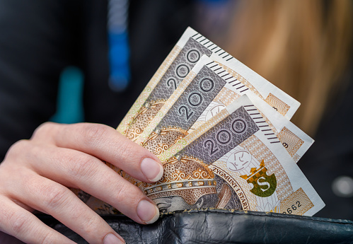Woman hides money in her wallet, Polish cash