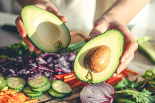 istock Close-up of a cut avocado in a woman's hands. 1962059176