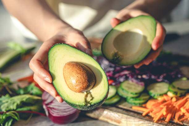 istock Close-up of a cut avocado in a woman's hands. 1962059187