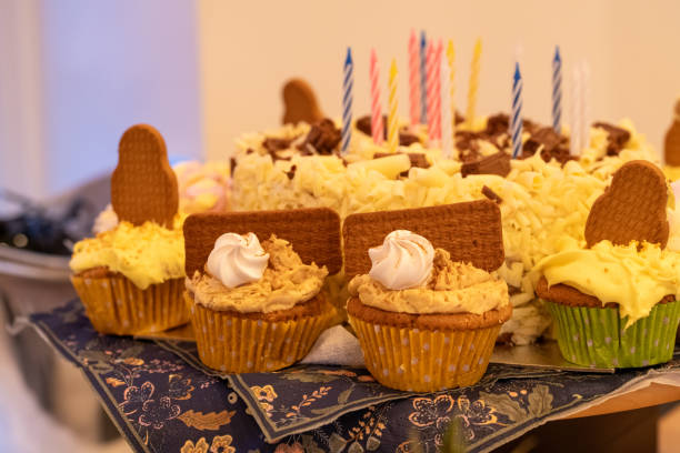 Delightful creamy homemade cupcakes covered in butter icing surrounding a white chocolate covered birthday candles with colourful candles waiting to be lit