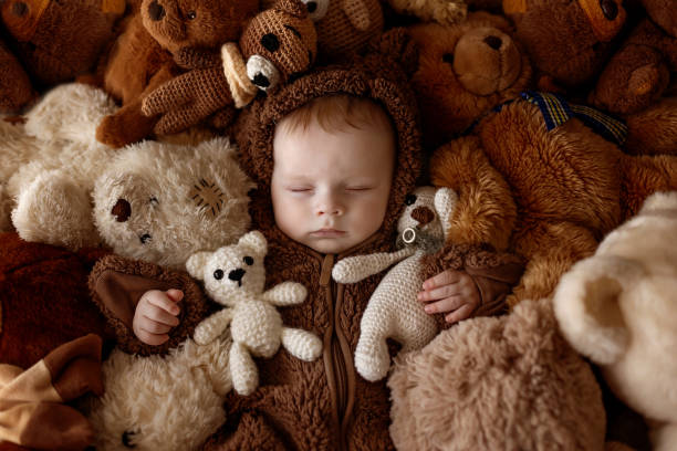 istock Sweet baby boy in bear overall, sleeping in bed with teddy bear 1962097493