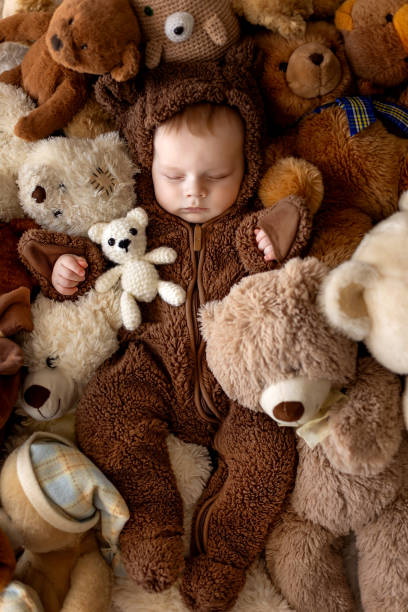 istock Sweet baby boy in bear overall, sleeping in bed with teddy bear 1962100677