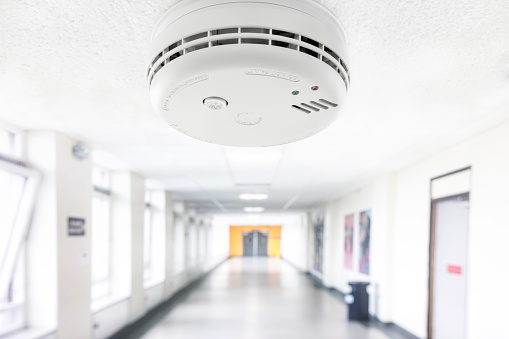 Smoke and fire alarm detector in hospital corridor or school hallway