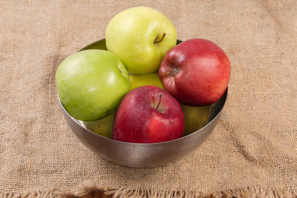 Young women taking apple from fruits bowl
