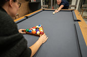 Couple enjoying playing billiard together in hotel