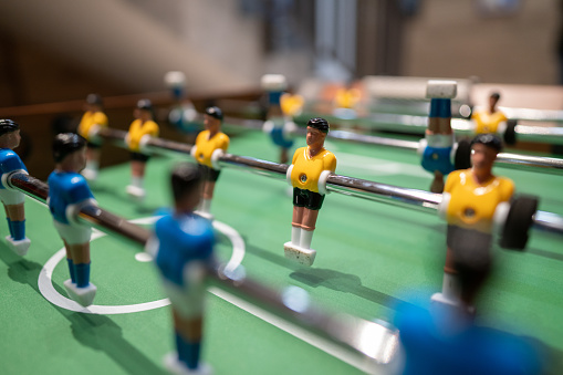 Close-up shot of figurines on table football in the hotel entertainment room without people