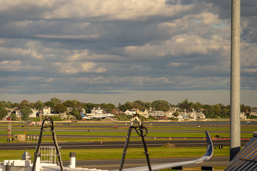 Logan International Airport, Boston Massachusetts, USA - October 2023.  Aircraft on the hard standing and the runway at the airport.
