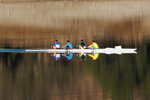 Beniarres, Spain, January 25, 2024.  Canoe training for 4 people in the Beniarres reservoir with beautiful light and reflections in the morning