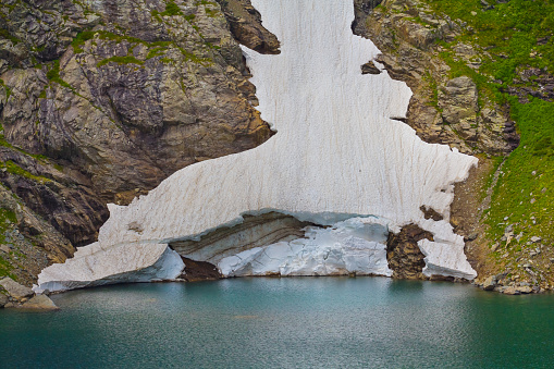 closeup emerald mountain lake with glacier on coast