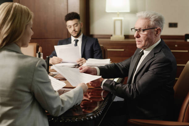Group of Business People Doing Paperwork Sitting in Boardroom