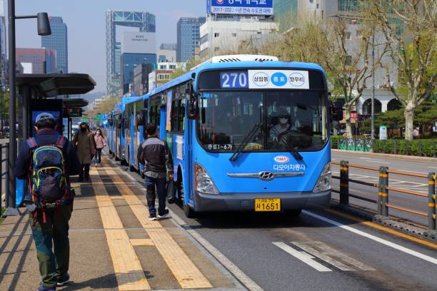 City bus in Jongno, Seoul Passengers board city buses on Jong-ro street in Jongno district of Seoul. seoul bus stock pictures, royalty-free photos & images