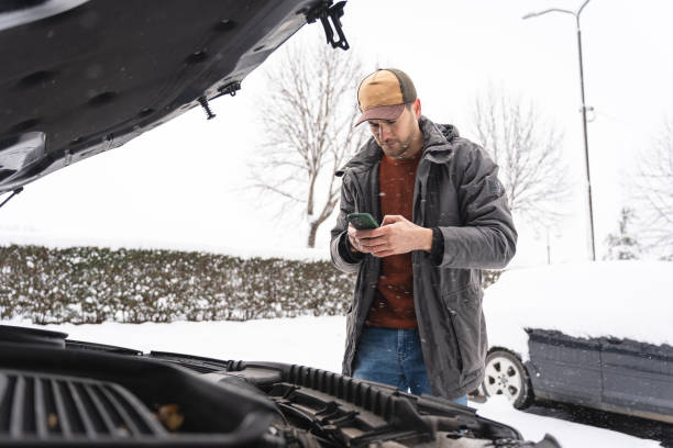 istock Worried Caucasian man, using mobile phone while standing near car, after an breakdown on winter cold weather 1962328937