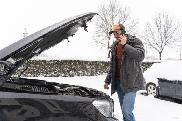 istock Worried driver talking on mobile phone, while standing near car, after an vehicle breakdown in winter cold weather 1962331627