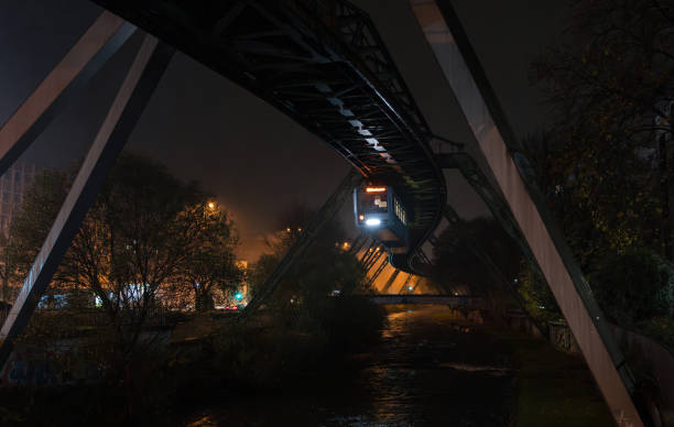 istock Schwebebahn - elevated suspension monorail cable car train, famous technological landmark and tourist attraction. Night cityscape of Wuppertal, North Rhine-Westphalia, Germany. 1962354071
