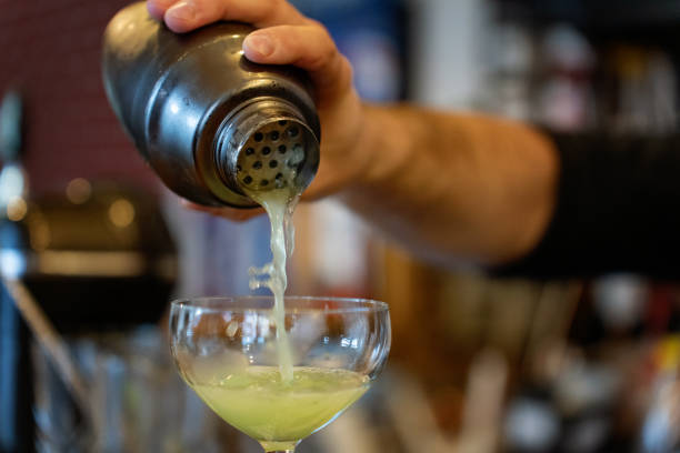 istock Bartender pouring lemon juice - preparing alcohol cocktail 1962386524