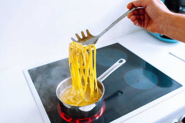 istock man cooks pasta spaghetti at home in kitchen. 1962411295
