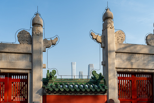 Nearby is the stone gate of Ritan Park (Temple of Sun), and in the distance is several high-rise skyscrapers in Beijing's Central Business District, which composes a picture of conflict and integration of history and present.
