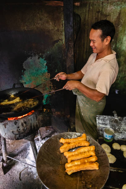 istock Burmese man preparing and selling fresh Chinese doughnuts, Myanmar 1962444968