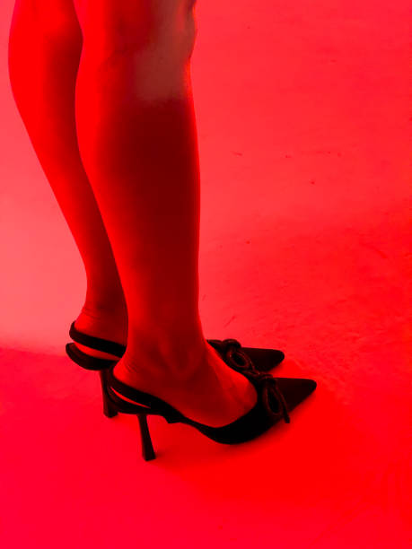 istock Girl's legs on a red background in a photo studio 1962461859