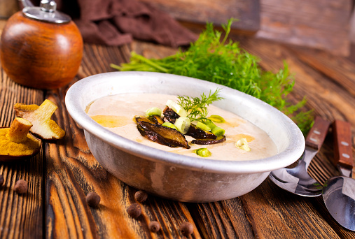 Cream-soup with porcini mushroom with croutons on wooden table