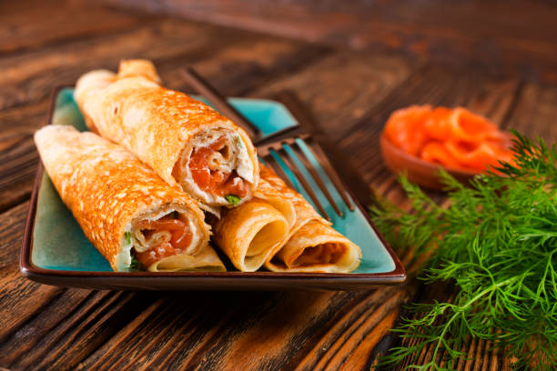 istock Pancakes with fish salmon, cheese and dill on wooden table 1962467662