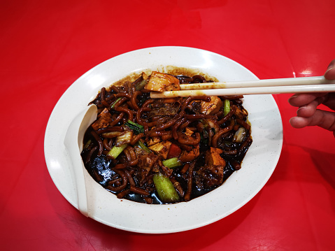 Focus scene on stir fried 'Hokkien Mee' (dark sauce vegetarian thick noodle) in restaurant