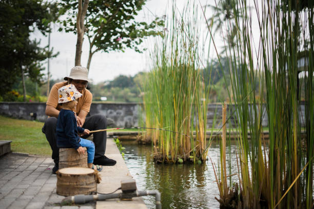 istock asian father spending time with his son while teaching him fishing 1962517698