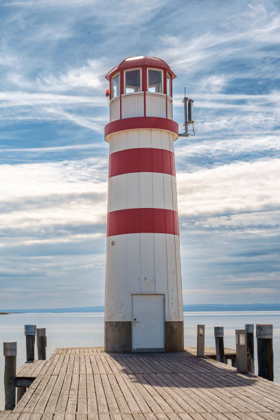 istock Lighthouse on the pier on lake under the moody sky 1962521613