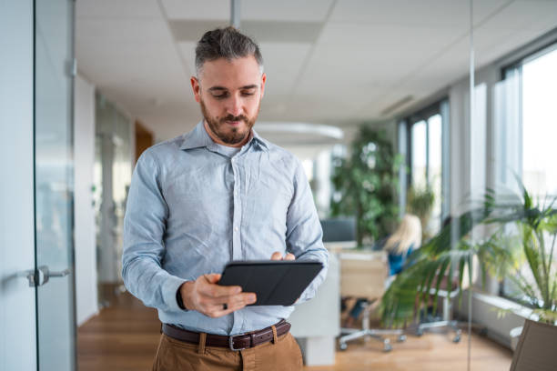 istock Stressed Mid Adult Caucasian Male Employee Utilizing Wireless Technology in the Workplace 1962527088
