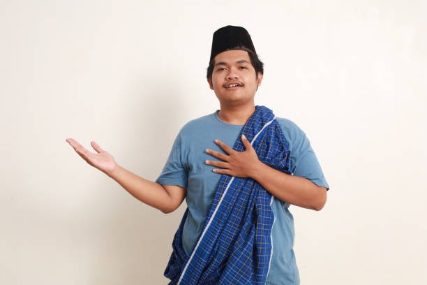 istock Asian muslim boy presenting sideways with happy face expression. Isolated on white 1962549037