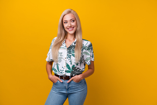 Photo of satisfied adorable woman with straight hairdo dressed print shirt look at sale empty space isolated on yellow color background.