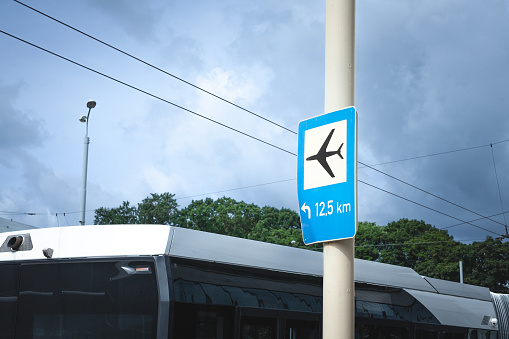 Roadsign indicating the direction to the Airport of Riga with an airport shuttle bus ready for departure. RIX, or Riga Airport is the main airport of Latvia.