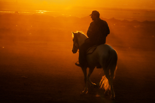 Kayseri, Turkey, May 5, 2017: A horse and cowboy riding his horse running at sunset golden hour