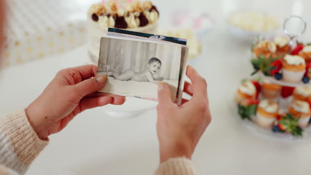 Closeup, hands and person with photos for a memory, nostalgia or celebration in a house. Back, party and looking at pictures at a social, birthday or event to remember the past with an image