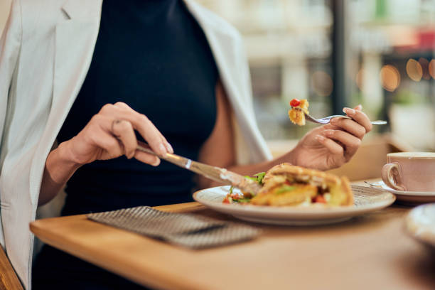 istock Female hands using fork and knife, eating breakfast at the restaurant. 1962590701