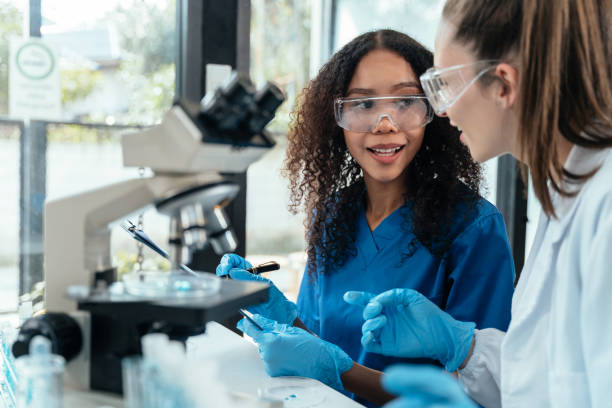 istock Team of biochemical research scientists working with a microscope for vaccine development in pharmaceutical research labeling. 1962598385