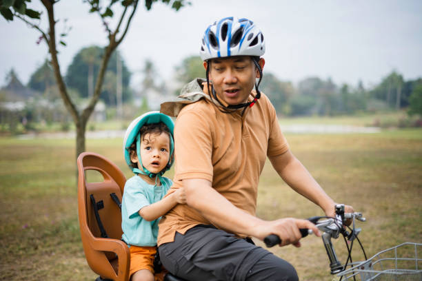 istock Father riding bicycle in park 1962619906