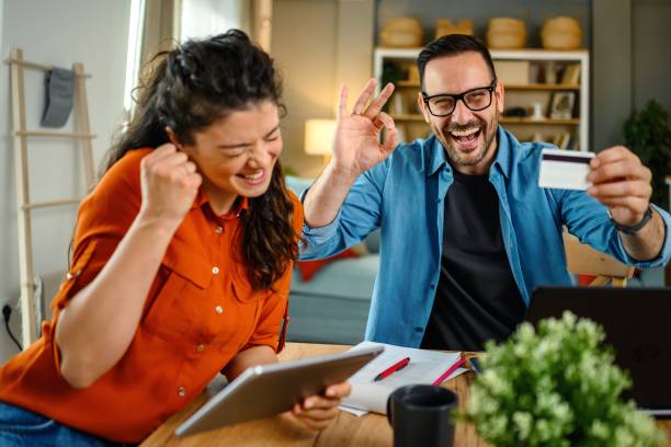 istock Couple smiling and showing a credit card. 1962624891