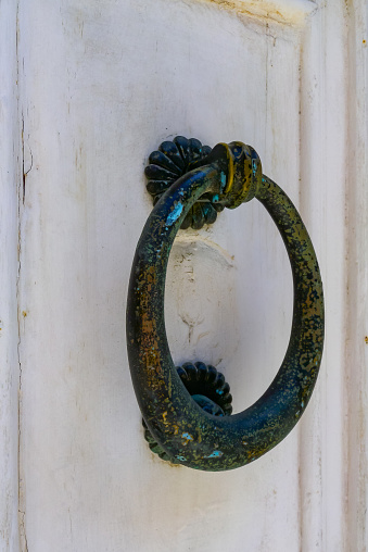 Traditional copper handle and door knocker on wooden doors of old houses in Malta, Gozo