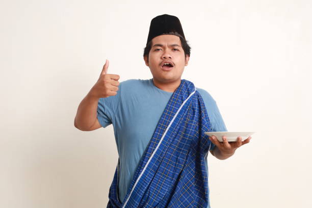 istock Wow excited asian muslim boy holding an empty plate while showing thumbs up. Isolated on white 1962648112