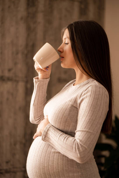 istock Pregnant woman drinking coffee or tea at home 1962648210