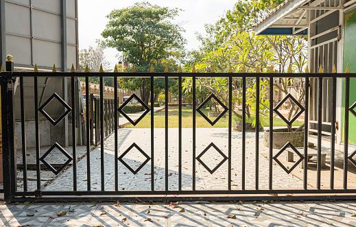 Metal Gate Adorning Urban Park's Brick Wall with Stone Stairs and Decorative Iron Elements