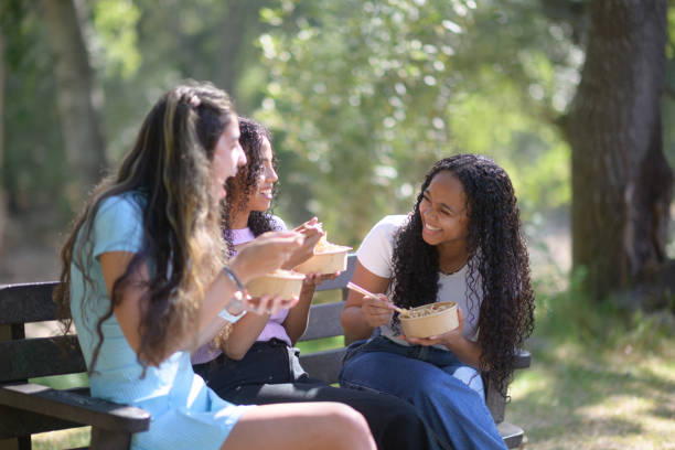 istock Young women sitting outdoors eating noodles 1962706447