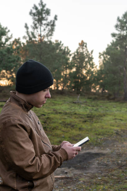 istock Caucasian man in nature looking at his phone 1962710112