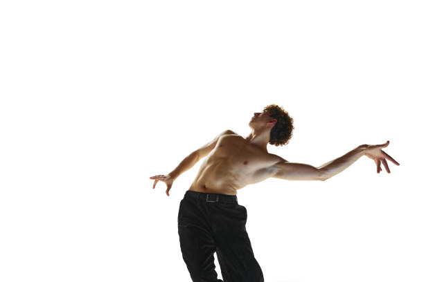 equilíbrio. jovem homem desnudado, bailarino executando dança contemporânea contra fundo de estúdio branco. - motion muscular build dancing ballet - fotografias e filmes do acervo