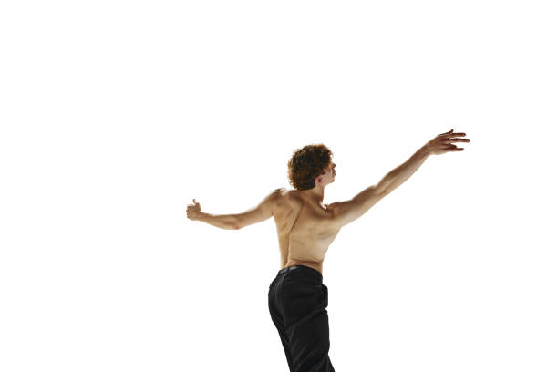 retrato retrovisor de um jovem musculoso dançando em movimento com as mãos levantadas contra o fundo branco do estúdio. movimento. - motion muscular build dancing ballet - fotografias e filmes do acervo