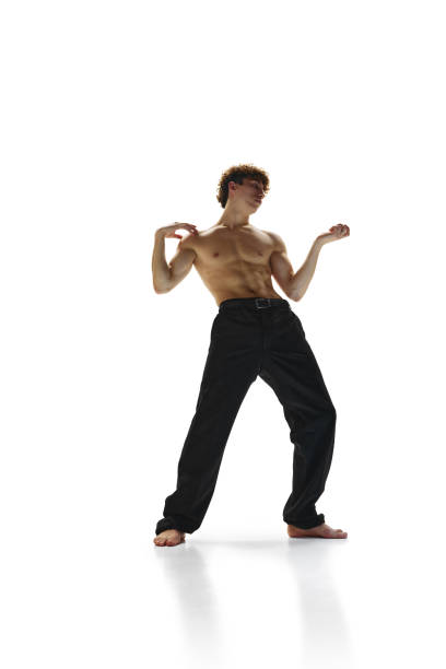 movimento de congelamento. jovem coreógrafo masculino com torso nu dançando em movimento contra fundo de estúdio branco. - motion muscular build dancing ballet - fotografias e filmes do acervo