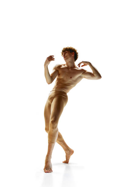 full length portrait of shirtless young man with athletic body, dancing in beige leggings against white studio background. - motion art naked studio shot imagens e fotografias de stock