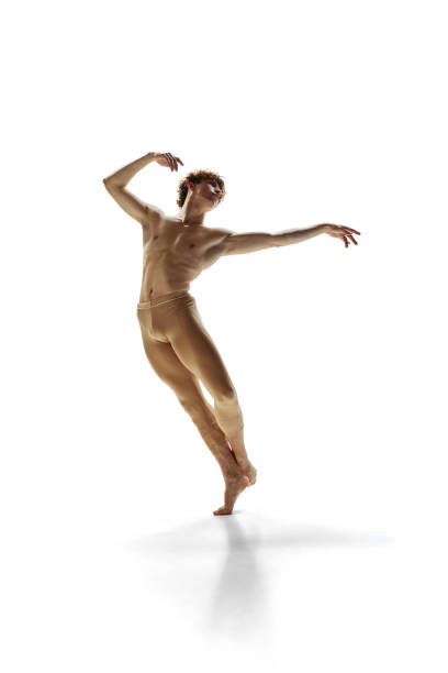 jovem atlético, bailarino moderno vestido leggings bege treinamento de movimentos de dança contra o fundo branco do estúdio. - motion muscular build dancing ballet - fotografias e filmes do acervo
